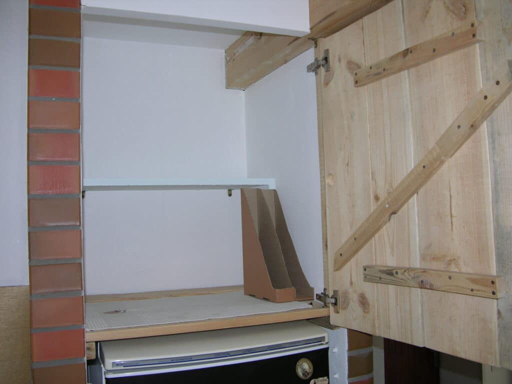 Above refrigerator space with two shelves & an oven pans organizer
